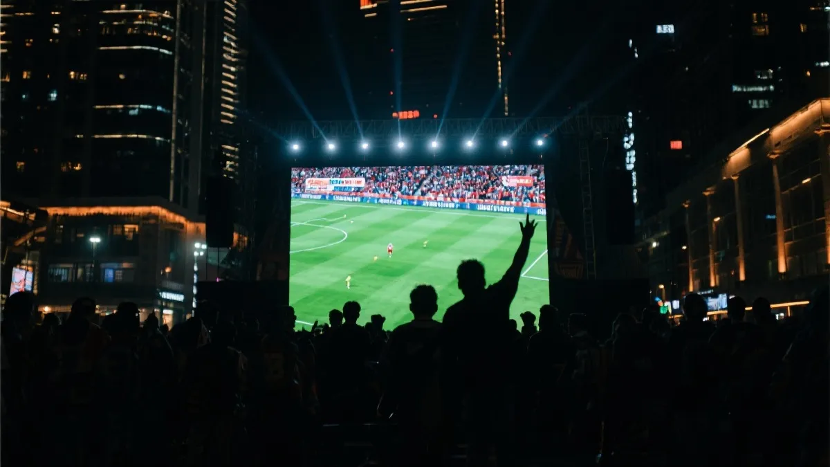 球迷在城市球迷广场观看大屏直播，夜景与人群氛围